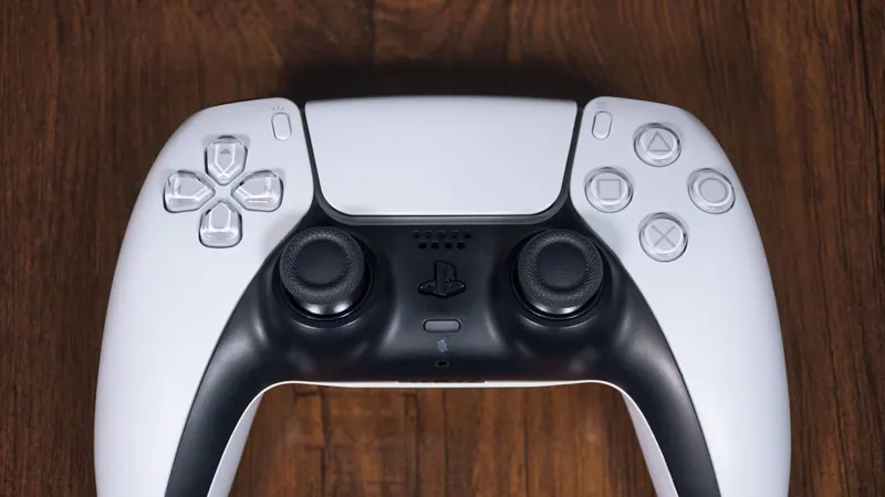 Игровая консоль PlayStation 5 и геймпад на деревянном столе