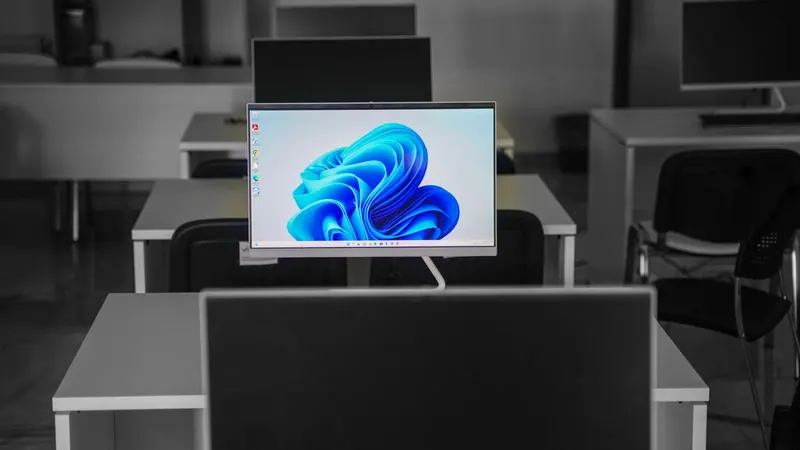 современный монитор с рабочим столом операционной системы на письменном столе